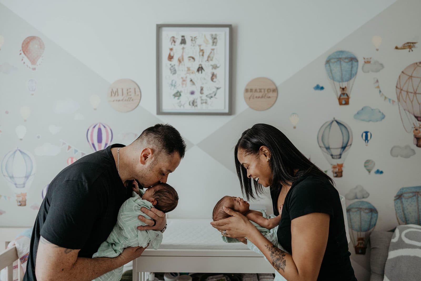 Grant recipients cradling their newborn twins in the nursery